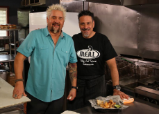 • Chef George Patti and Guy Fieri on set for Diners, Drive-ins and Dives (Season 24, Episode 8: “Hot Meat and Cool Veg” aired April 22, 2016) pictured with Housemade Pork Rinds and Chimichurri Aioli; photo courtesy of M.E.A.T. Eatery And Taproom • Chef George Patti and Guy Fieri on set for Diners, Drive-ins and Dives (Season 24, Episode 8: “Hot Meat and Cool Veg” aired April 22, 2016) pictured with Housemade Pork Rinds and Chimichurri Aioli; photo courtesy of M.E.A.T. Eatery And Taproom