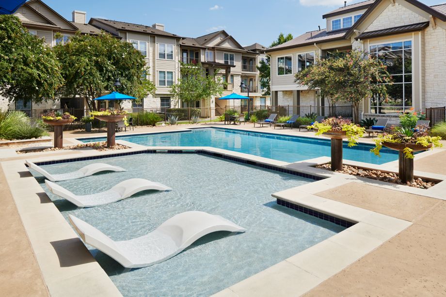 Swimming pool with lounge chairs at Camden Cedar Hills apartments in Austin, TX